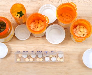 Prefilling once a day medication box with many pills. The importance of medication management cannot be overstated, especially when it comes to the care of seniors. Med boxes assist with management.